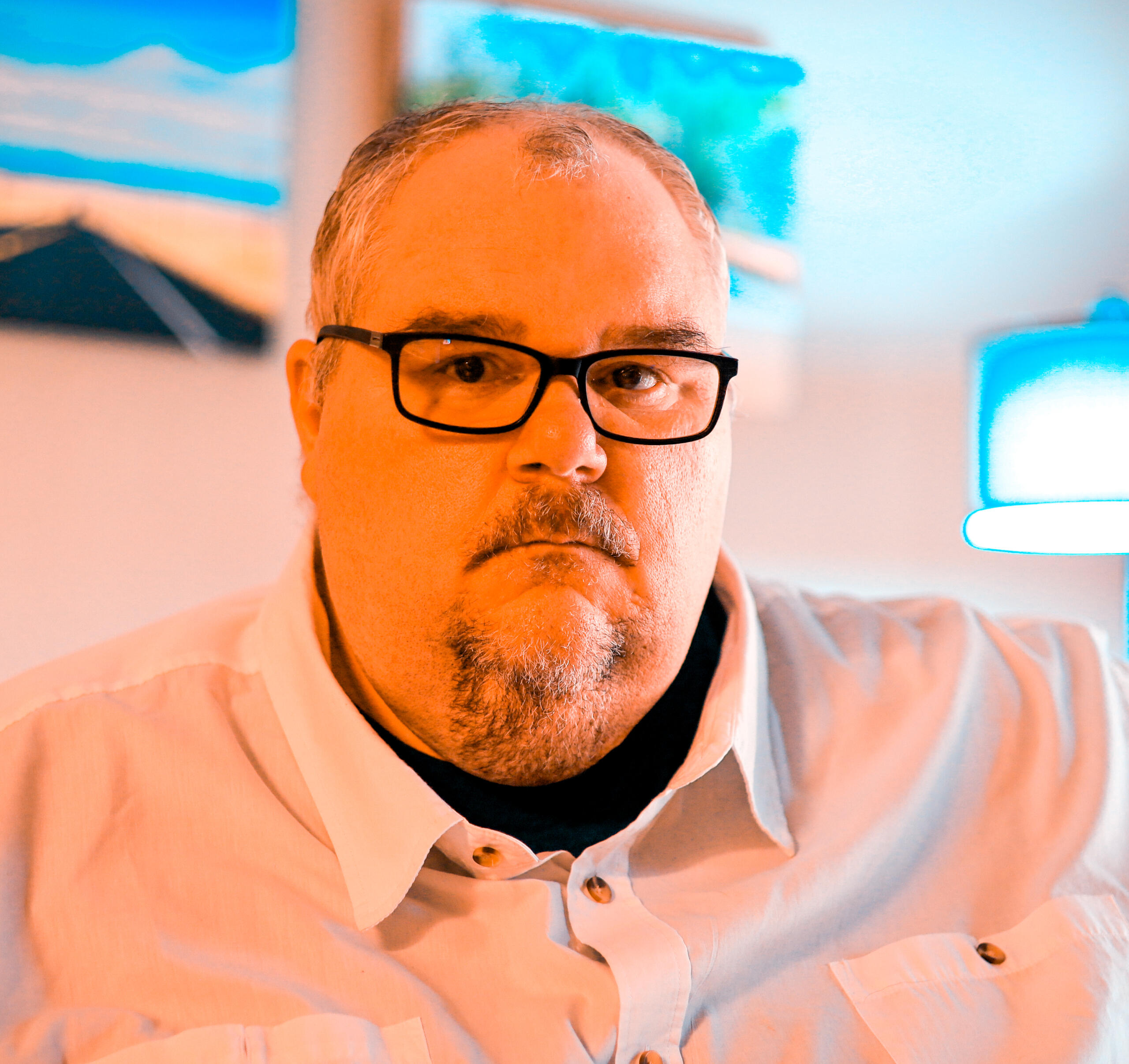 A man in a white shirt wearing black glasses in his news studio in San Antonio, Texas. Matt Pierce
